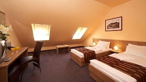 A hotel room with a desk, two beds, a chair, and a small table. - Erzsébet Királyné Szálloda (Godollo)