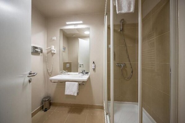 Une salle de bain avec un lavabo, un miroir et une douche.