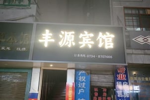 A hotel sign with the name '丰源宾馆' and a contact number.