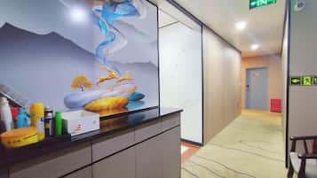 A reception area with a modern design, a reception desk, and a wall mural.