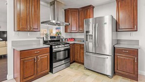 Una cocina moderna con armarios de madera, electrodomésticos de acero inoxidable y una isla central.