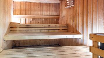 Un sauna en bois, doté de bancs et d’un plancher incliné.