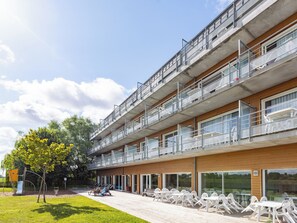 Ein mehrstöckiges Gebäude mit Balkonen, Außenbereich und einem Spielplatz.