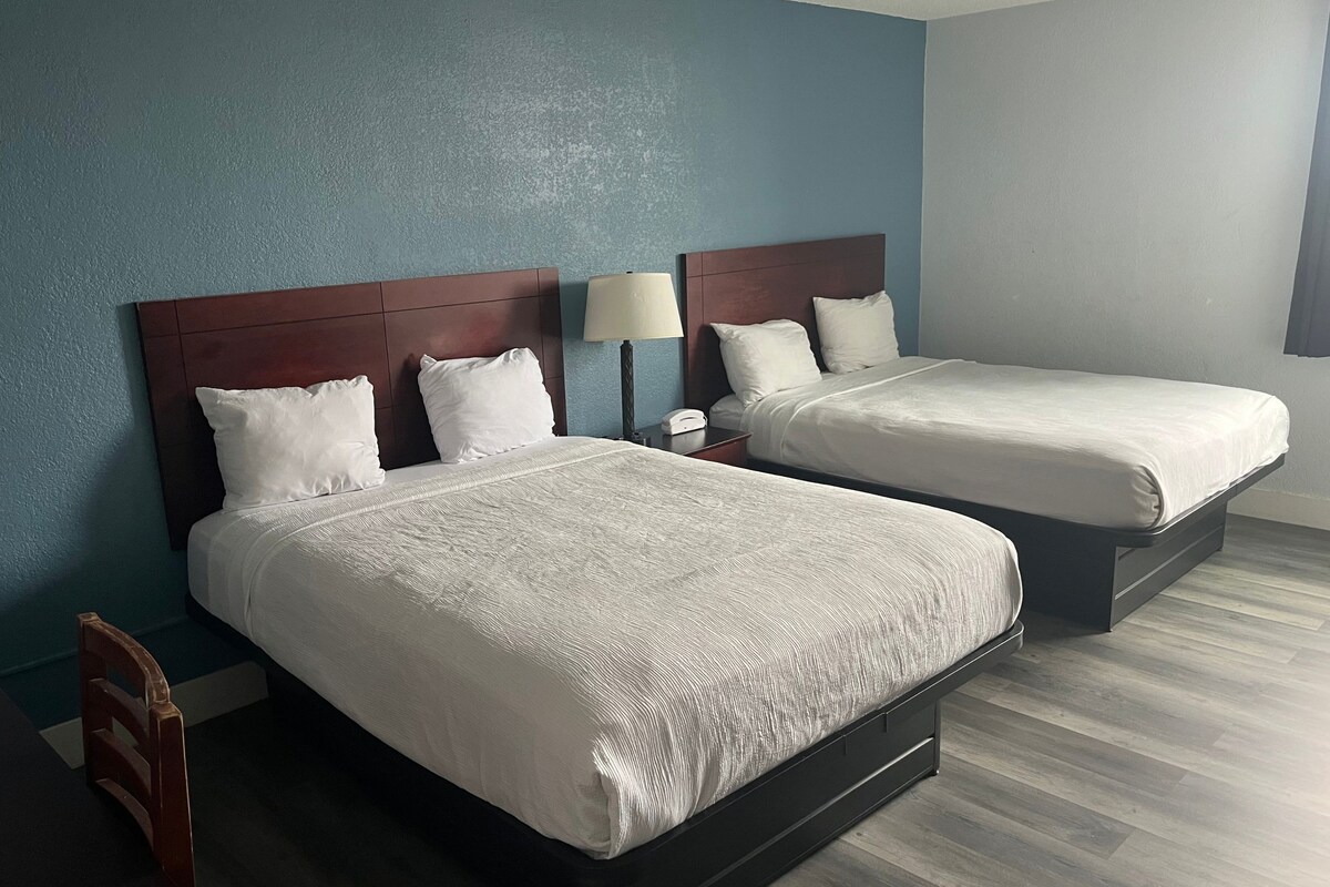 Two single beds with wooden headboards in a hotel room.