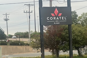 A sign for Coratel Inn by Jasper, featuring a logo and name. - Coratel Inn and Suites By Jasper Roseville (Roseville)