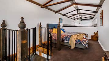 Cozy retreat with a high ceiling and industrial-style interior, featuring a comfortable bed and a simple, functional design.