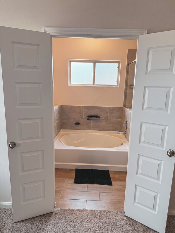 A bathroom with a bathtub, a window, and a shower. - Hypebeast VIP Lounge w/ Private Sauna- Event Space (Cypress)