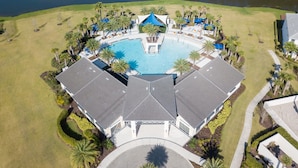 An aerial view of a resort with a central swimming pool, surrounded by palm trees and a body of water. - Grand 15-bedroom Villa -magical Themes, Pool & Game Loft, Lakeview (Kissimmee)