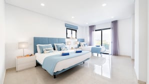 A modern bedroom with a large bed, bedside tables, and a view of the outdoors.