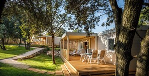 Een moderne patio met houten terras, zitplaatsen en uitzicht op een woongebouw.
