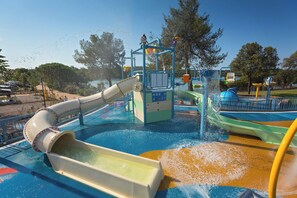 Ein Wasserpark mit Wasserrutsche, Spritzbereich und verschiedenen Spielgeräten.