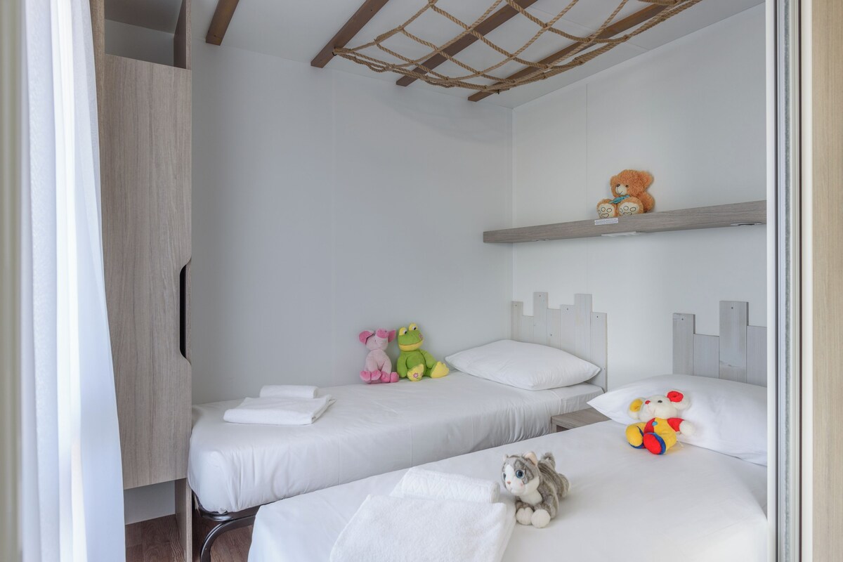 Ein Schlafzimmer mit zwei Betten, einem Kleiderschrank und einem Regal mit Stofftieren.