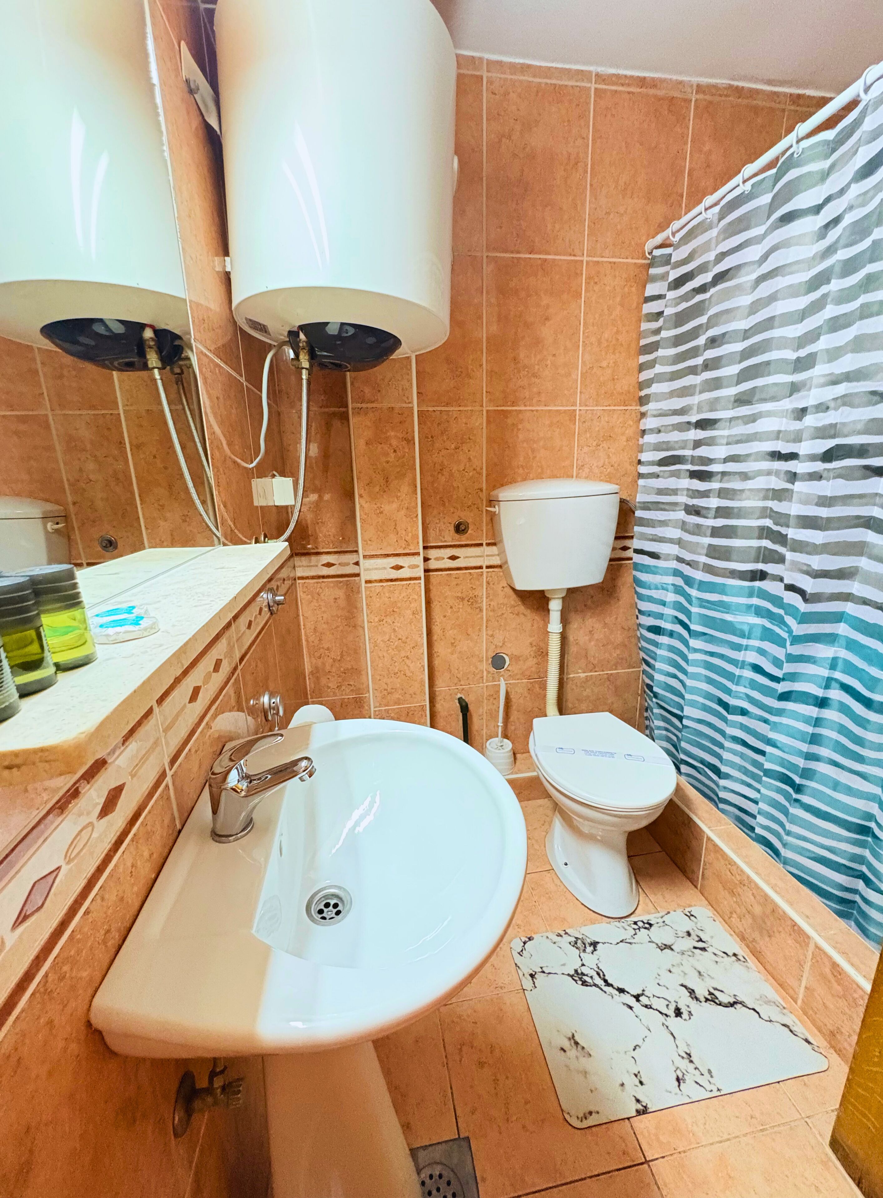 A bathroom with a sink, toilet, and shower.