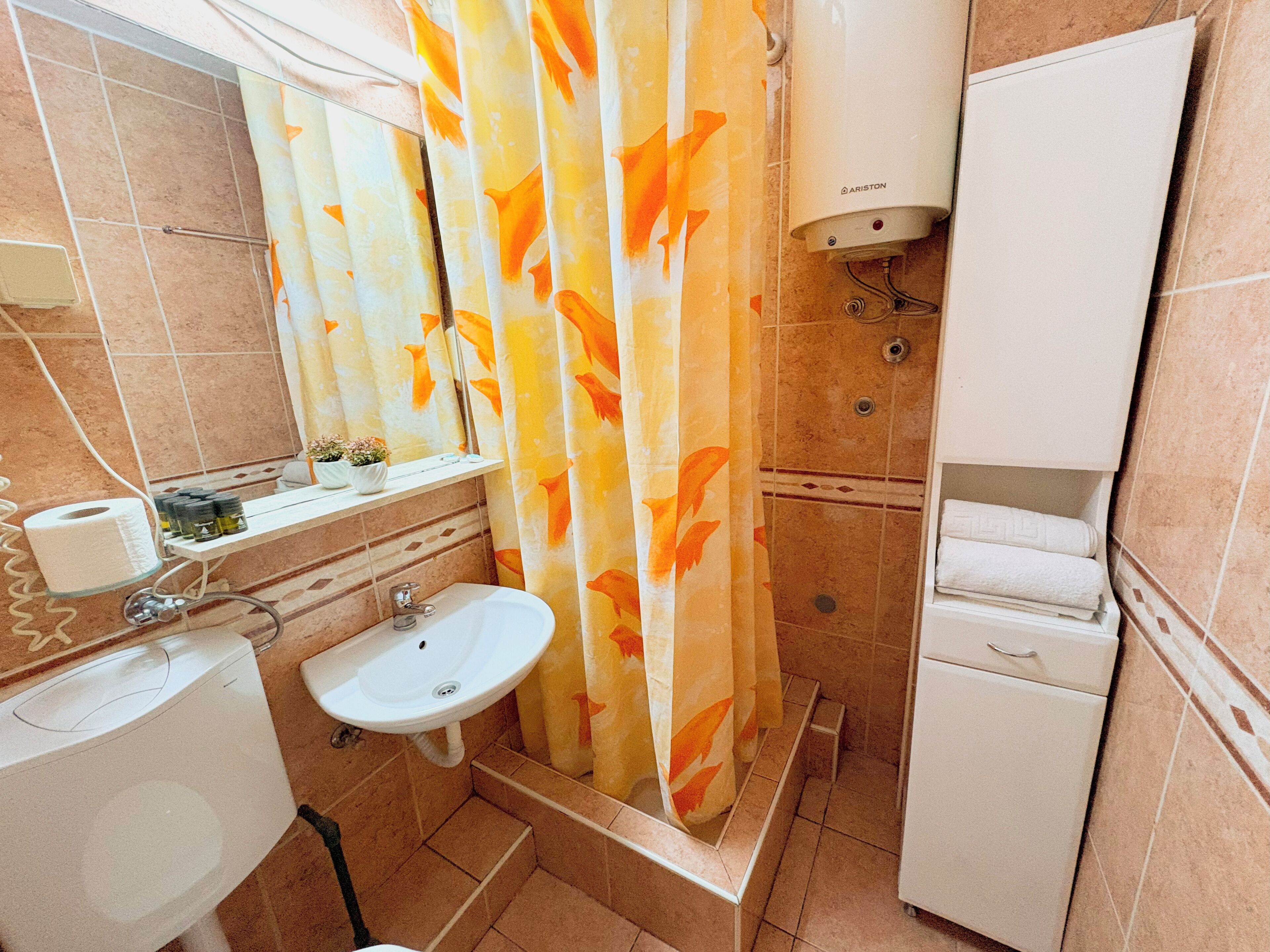 A bathroom with a toilet, sink, and shower area.