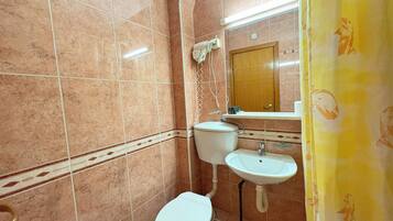 Un baño con inodoro, lavabo y espejo.