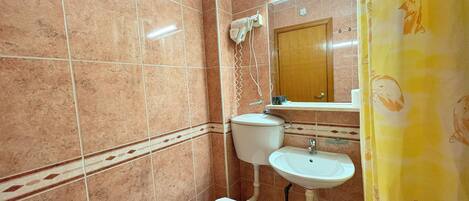 Un baño con inodoro, lavabo y espejo.