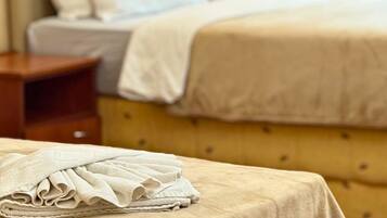 Una habitación de hotel con una cama, una mesita de noche, una lámpara y un cuadro en la pared.
