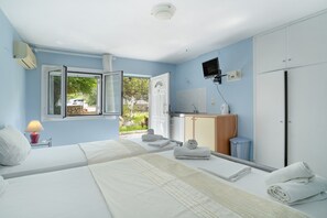 A hotel room with a bed, a desk, a TV, a wardrobe, and a bathroom.