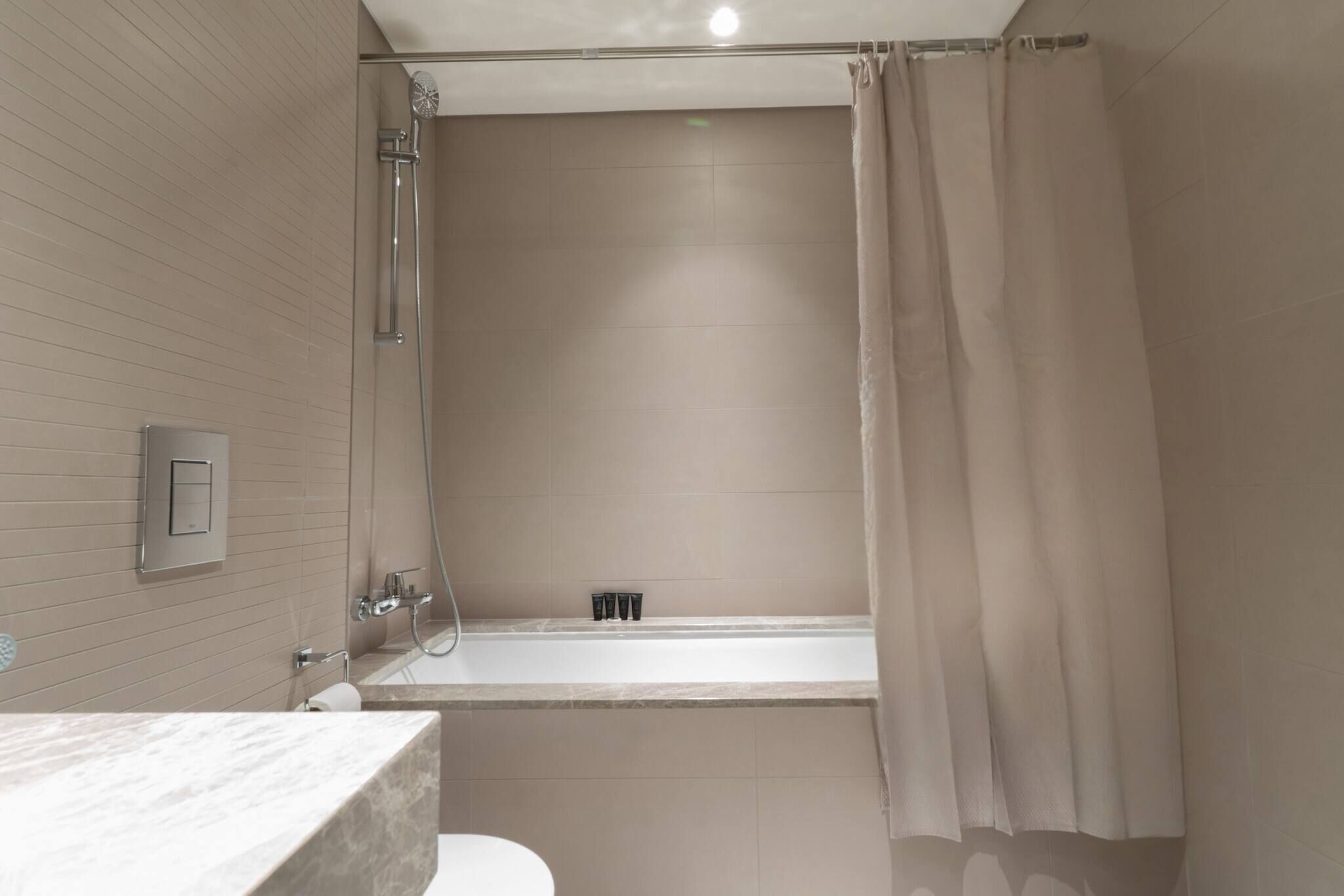 Une salle de bain moderne équipée d’une baignoire, d’une douche et de toilettes.