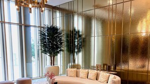 Ein moderner Lounge-Bereich mit einer gebogenen Couch, runden Hocker und einem zentralen Couchtisch.