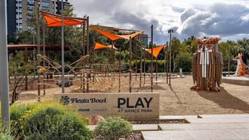 Un parque con un cartel que dice 'Fiesta Bowl PLAY AT HANCE PARK' y una estructura de madera que parece un búho.