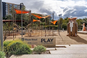 A park with a sign reading 'Fiesta Bowl PLAY AT HANCE PARK' and a wooden structure resembling an owl.