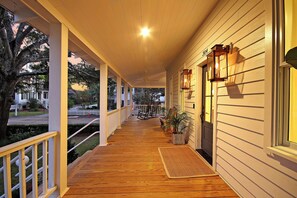 A wooden porch with a white railing, a ceiling fan, and a potted plant. - Old Village Luxury – Historic 5BR, Walk to Dining, Shops, & Sunset Views (Mount Pleasant)