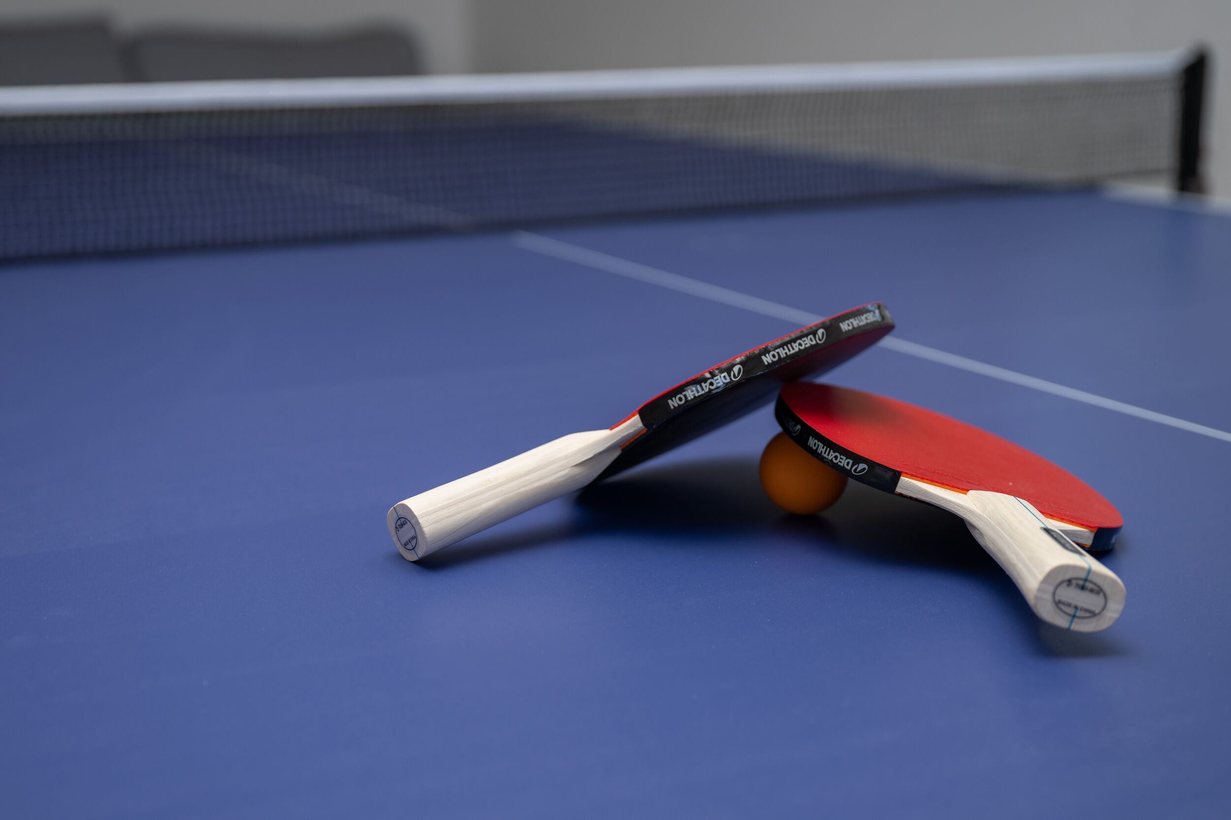 A table tennis table with a blue surface and a net.