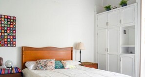 Cozy retreat with a comfortable bed, bedside table, and ample storage.