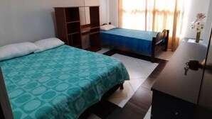 Una camera da letto con un letto, una scrivania e un armadio.