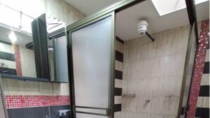 Un bagno con doccia, lavandino e specchio.