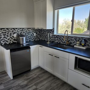 Fridge, microwave, coffee/tea maker, cookware/dishes/utensils