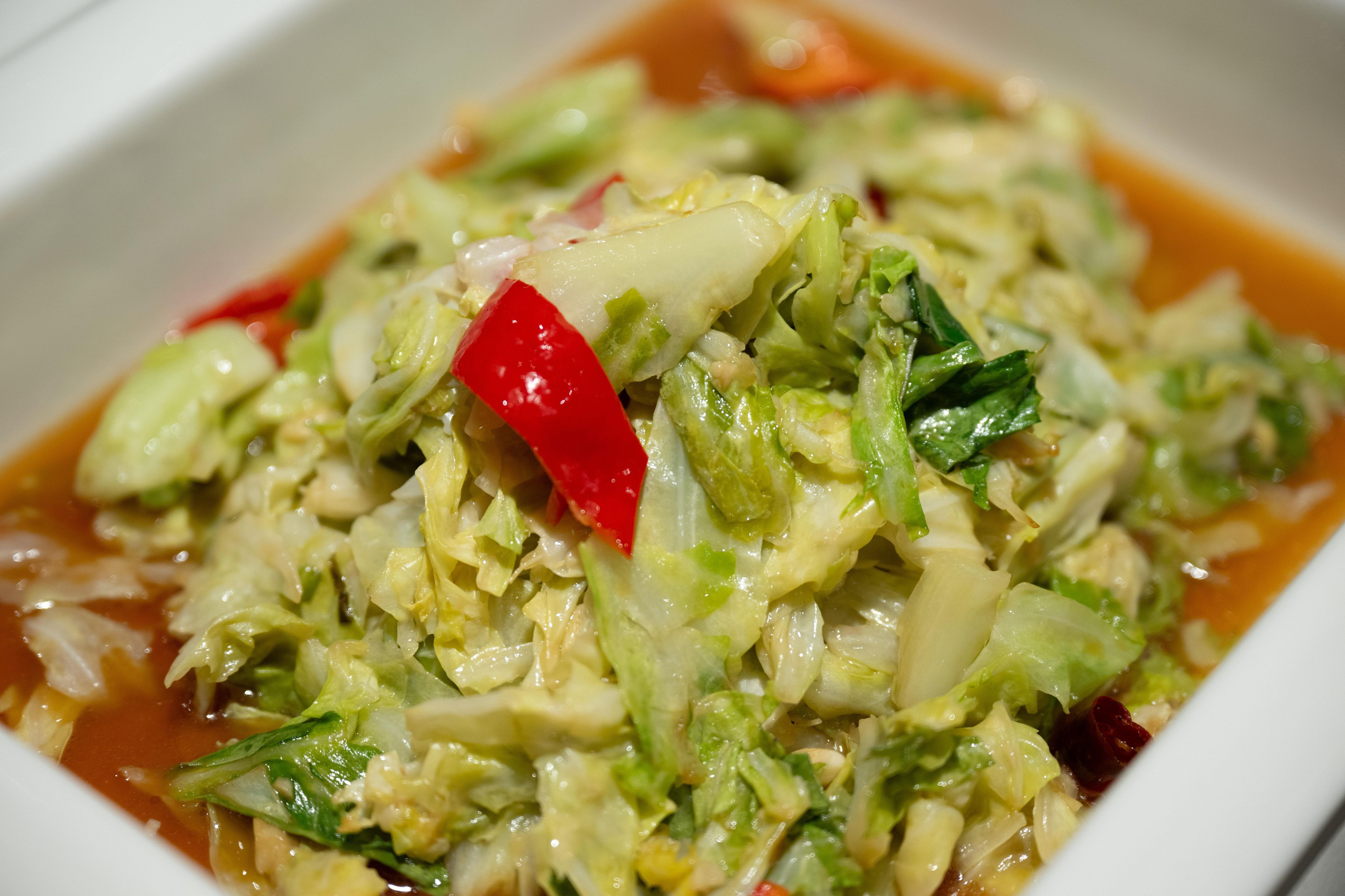Un plat composé de légumes variés et d’un piment rouge.
