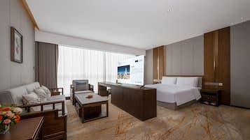 Une chambre d’hôtel avec un lit, un bureau, un canapé et une table basse.