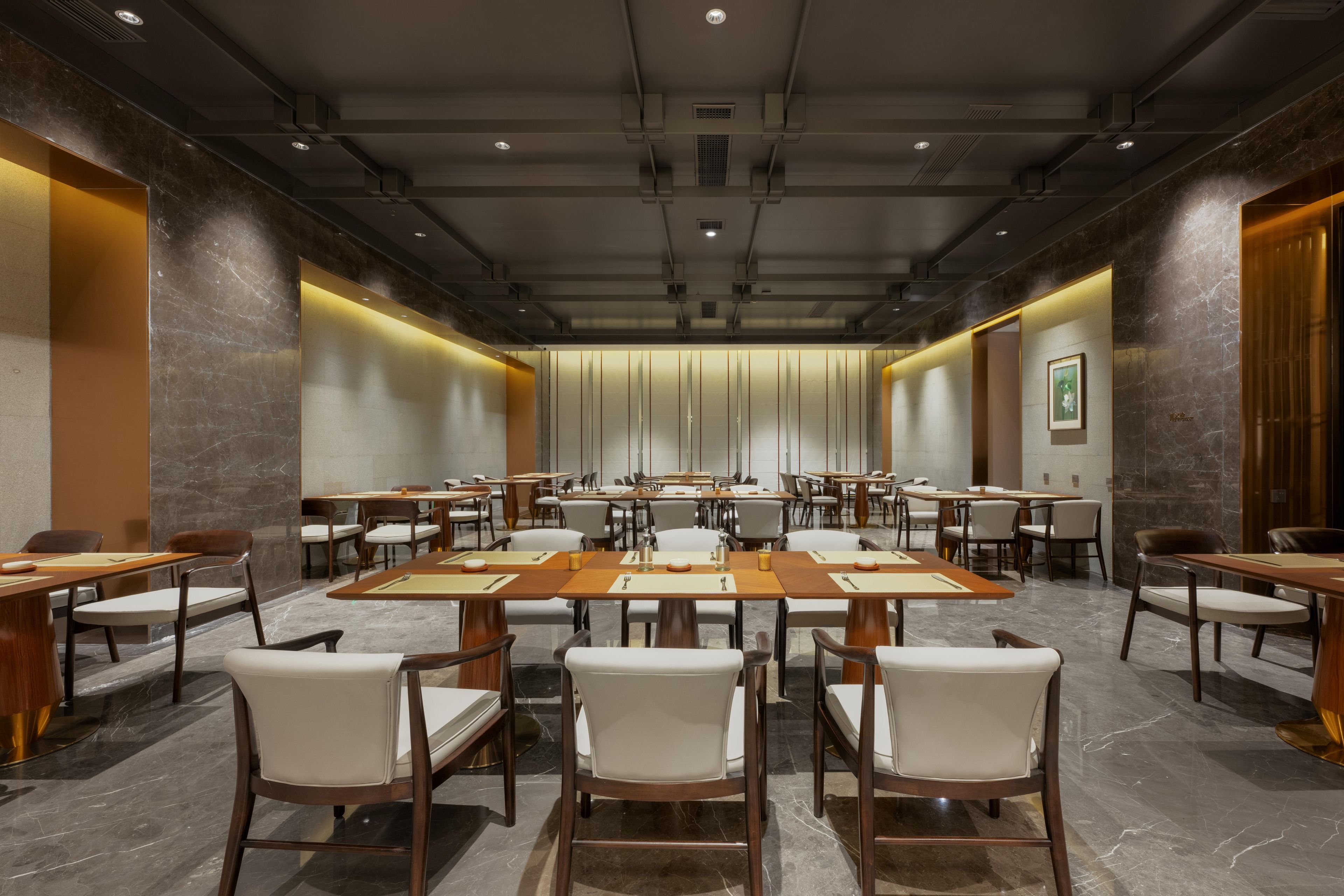 A conference room with multiple tables and chairs, equipped with nameplates and a projector.