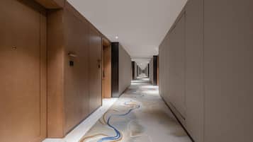 Un pasillo con puertas de madera y un suelo estampado.