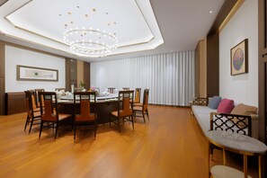 A modern dining area with a round table, chairs, and a chandelier. - Grand Madison Hotel Jining Yongrun (Jining)