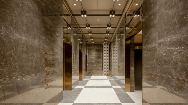 A modern elevator interior with marble walls and a checkered floor pattern. - Grand Madison Hotel Jining Yongrun (Jining)