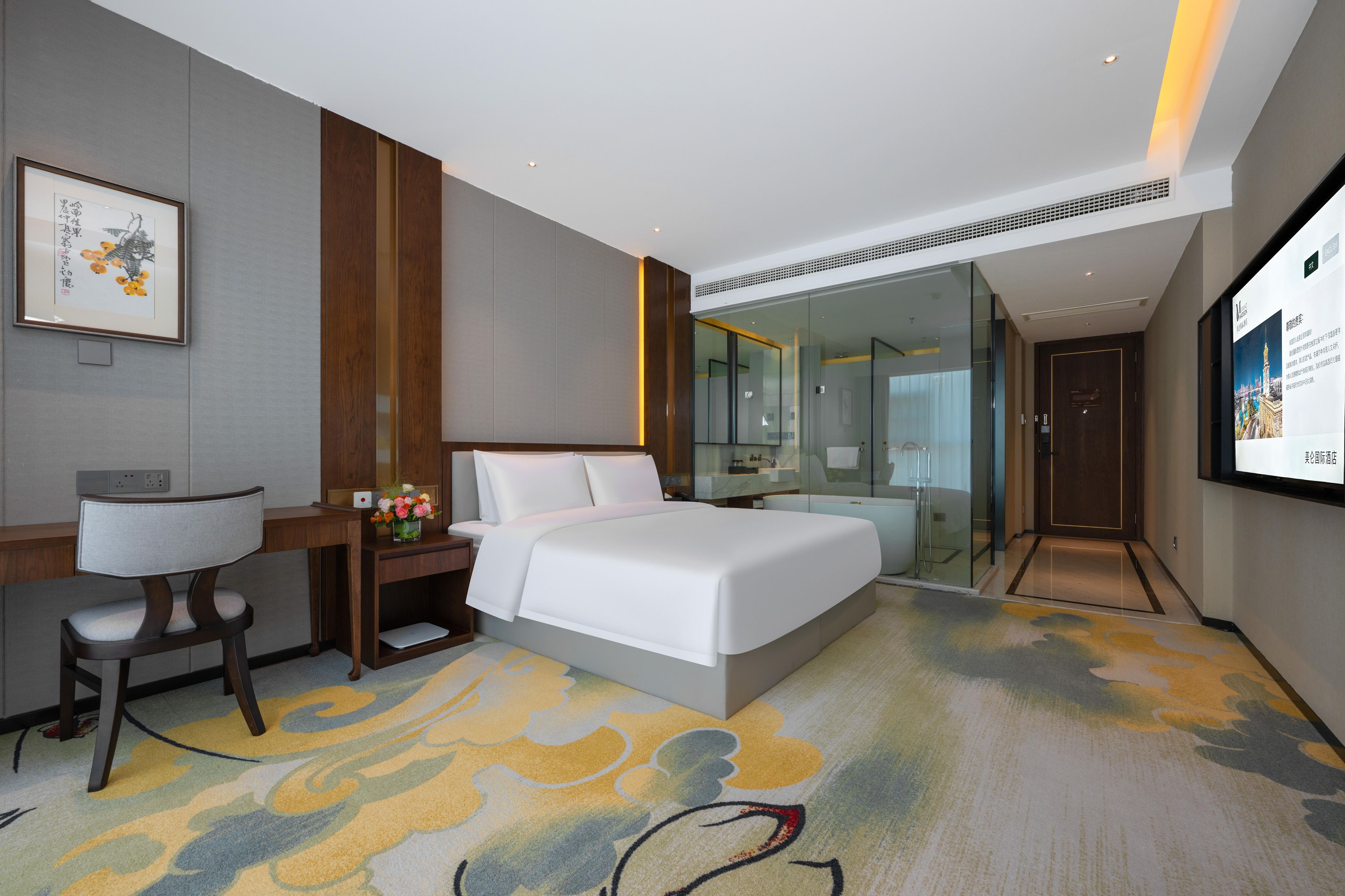 Habitación de hotel con cama, escritorio, silla y un espejo grande.