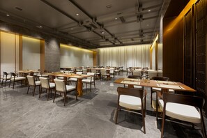 A modern conference room with multiple tables and chairs, equipped with nameplates and table settings. - Grand Madison Hotel Jining Yongrun (Jining)