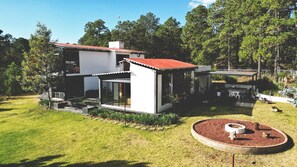 Relax in a serene setting surrounded by lush greenery and enjoy the patio area with outdoor furniture.