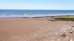 Una platja amb cel blau i mar tranquil·la.