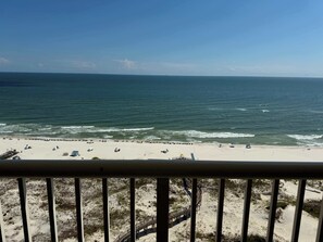 A beach with a wooden walkway leading to the water, a sandy beach, and a clear view of the ocean.