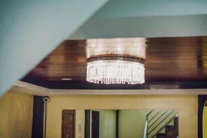 A room with a chandelier, a staircase, and a door. - Gabz'k Travellers Inn (Sorsogon City)