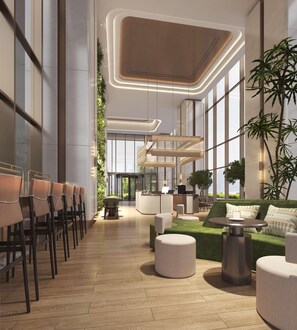 A modern lobby with a central staircase, seating areas, and large windows. - Hilton Garden Inn Chongqing Yubei Central Park (Chongqing)
