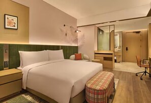 A modern hotel room with a large bed, a bedside table, a bench, a desk, a mirror, and a bathroom. - Hilton Garden Inn Chongqing Yubei Central Park (Chongqing)