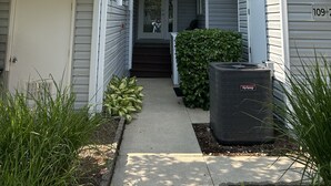 A two-story residential building with a narrow front entrance, a visible door, and a small step leading to the entrance.