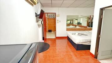 A hotel corridor with a bed, a desk, and a bathroom.