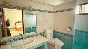 A bathroom with a sink, toilet, and mirror. - Malee Guesthouse & Restaurant (Pattaya)