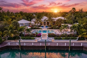 A resort with a swimming pool, palm trees, and a sunset view. - Below Deck Villa  Turks & Caicos (Leeward Settlement)